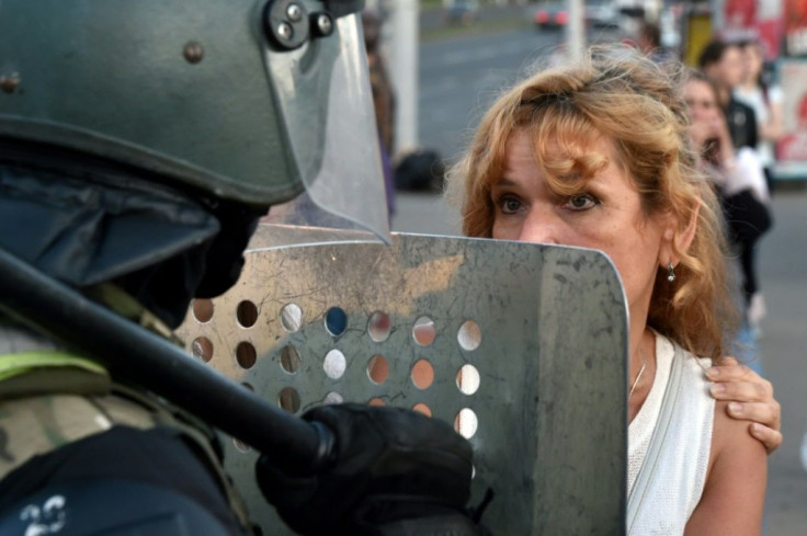A protesters stares down a Belarus riot police officer during another day of demonstrations against widely-criticised election results