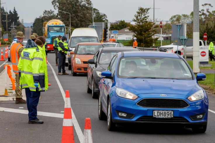 Police and military personnel check vehicles leaving Auckland as New Zealand rushes to track the source of a sudden return of the coronavirus