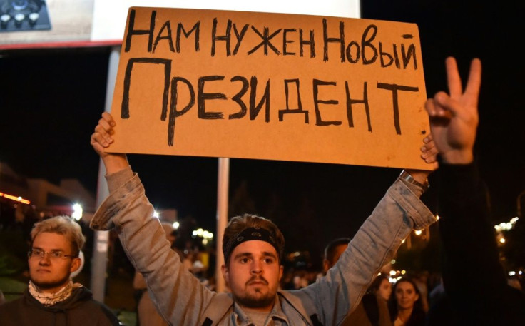 A man holds a poster reading "We need a new President" during a protest rally against police violence in the wake of the disputed re-election of strongman Alexander Lukashenko