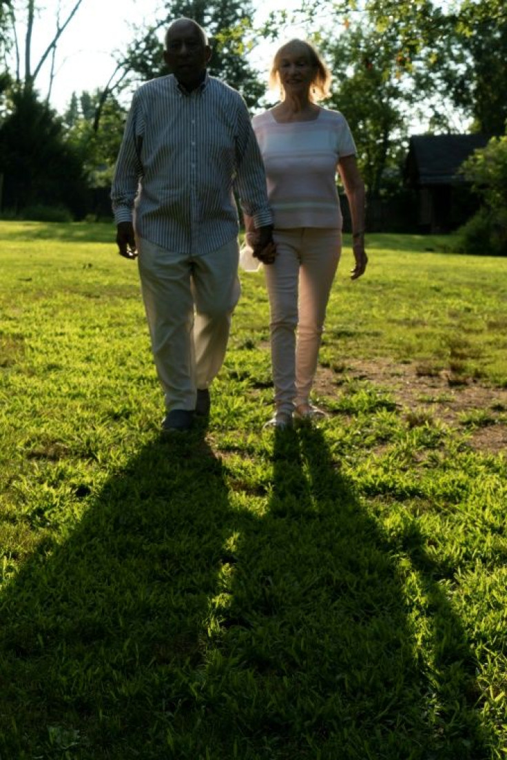 Dan Smith and his wife Loretta Neumann walk in the backyard of their home in Washington's Takoma neighborhood