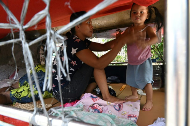 The wife of a jeepney driver with her daughter inside their temporary home