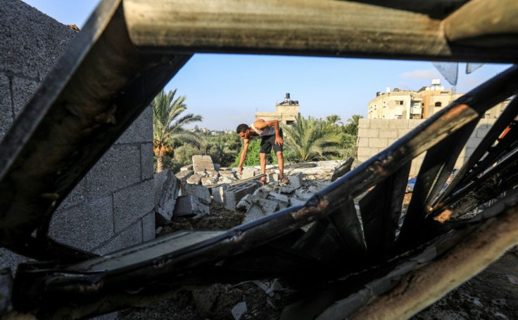 A man inspects rubble and debris on a rooftop following an Israeli air strike, east of al-Bureij camp for Palestinian refugees in the central Gaza Strip on August 15