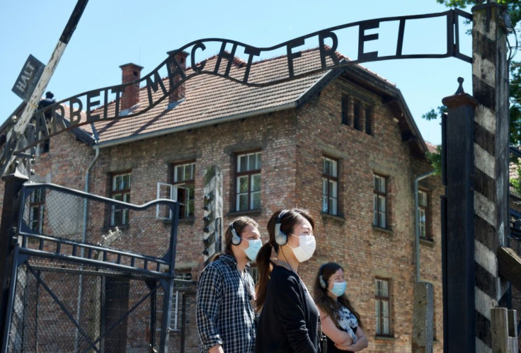 Visitors at the memorial site of the former German Nazi death camp Auschwitz, near the gate with the inscription "Work sets you free", on July 1, 2020
