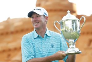 American Jim Herman celebrates with the trophy after winning the US PGA Tour Wyndham Championship in North Carolina to secure his place in the tour's FedEx Cup playoffs