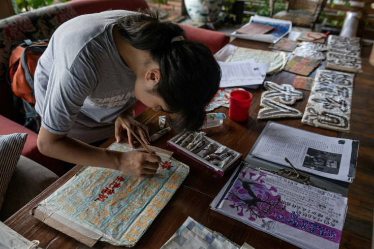 Ou paints signs and placards at her hostel in Guilin. Last summer she travelled solo around China meeting with environmental NGOs and activists but says many had little understanding of the climate crisis