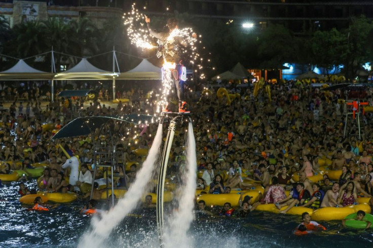 A performer on a water jet board entertained his audience by hovering above them with sparks shooting from his back