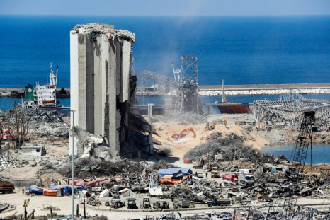 Diggers remove earth at the blast site next to the silos at the port of Beirut in the aftermath of the massive explosion