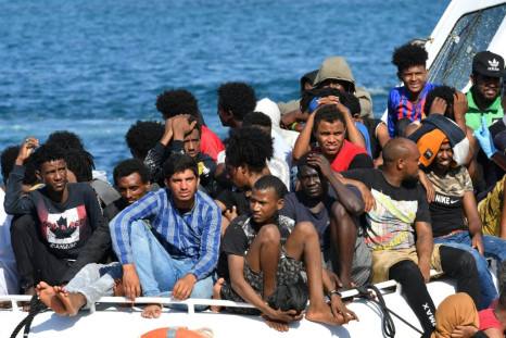 Migrants from Tunisia and Libya arrive onboard of an Italian Coast Guard boat on the Italian island of Lampedusa on August 1