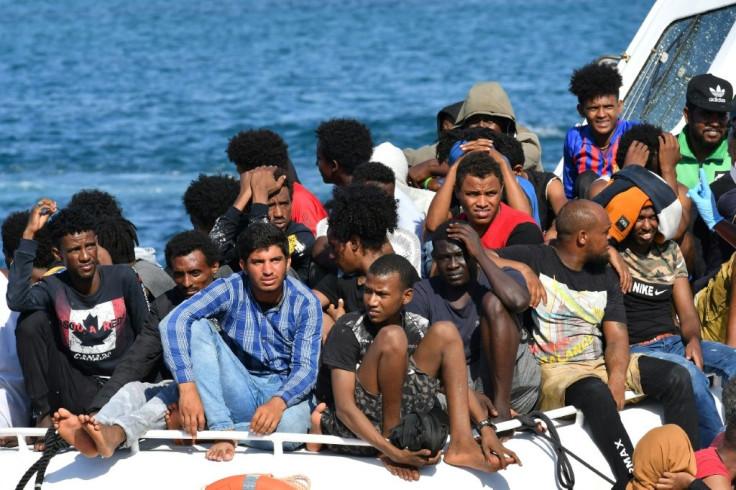 Migrants from Tunisia and Libya arrive onboard of an Italian Coast Guard boat on the Italian island of Lampedusa on August 1