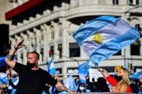 People wave Argentine flags during a protest in Buenos Aires against the government's tight lockdown measures against the spread of the novel COVID-19 coronavirus