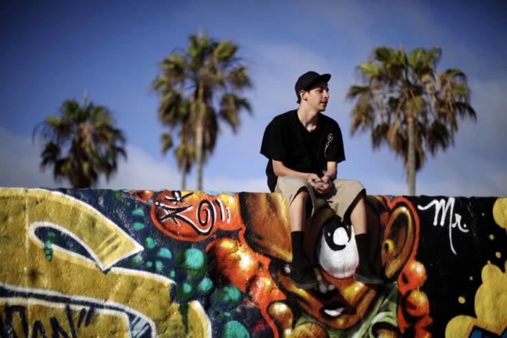 A teenager sits on a wall on Venice Beach in Los Angeles