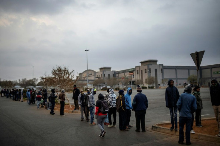 Customers queue while waiting for the opening of a liquor shop in Lenasia, Johannesburg, on Tuesday