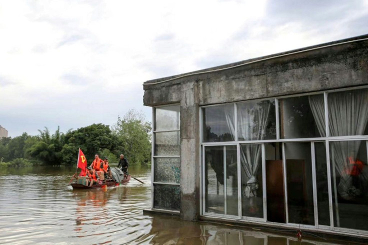 Community workers and volunteers deliver food and supplies to flood-affected residents after heavy rains in Neijiang, Sichuan