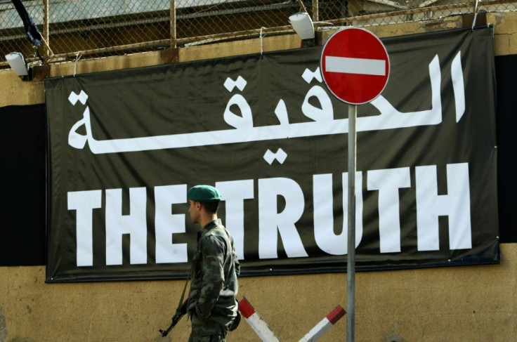 A Lebanese soldier stands guard near a giant banner reading "truth" in Arabic and English in Beirut