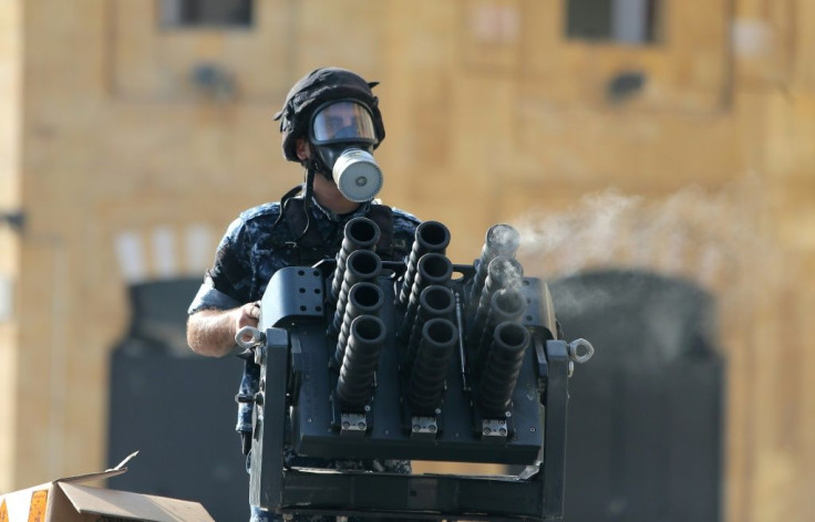 A member of the Lebanese security forces loads tear gas into a launcher during clashes in downtown Beirut on August 8