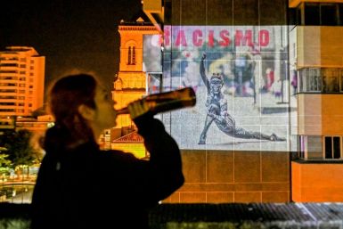 An image reading "Racism" is projected on a building wall in Medellin, Colombia on August 9, 2020