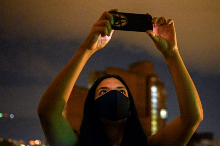 Colombian activist and filmmaker Laura Mora takes photos of a projection in Medellin