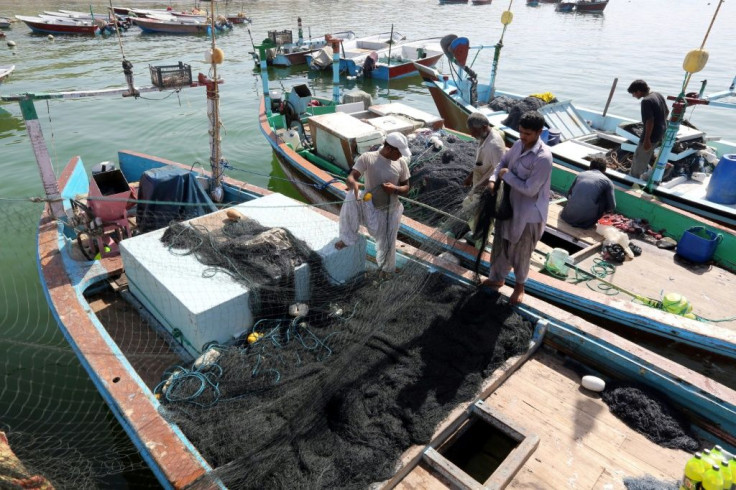 Iranian fishermen seen in this 2015 picture clean their nets after unloading their catch in the southern port of Chabahar