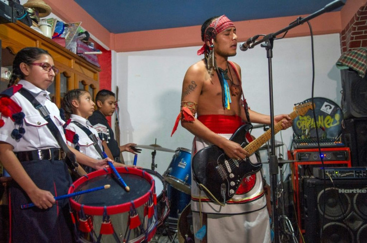 Victor Hugo Sandoval (R), vocalist and guitarist of Mexican rock band Los Cogelones, rehearses with his students -- members of a marching band -- in Ciudad Nezahualcoyotl, Mexico state, Mexico, on August 12, 2020