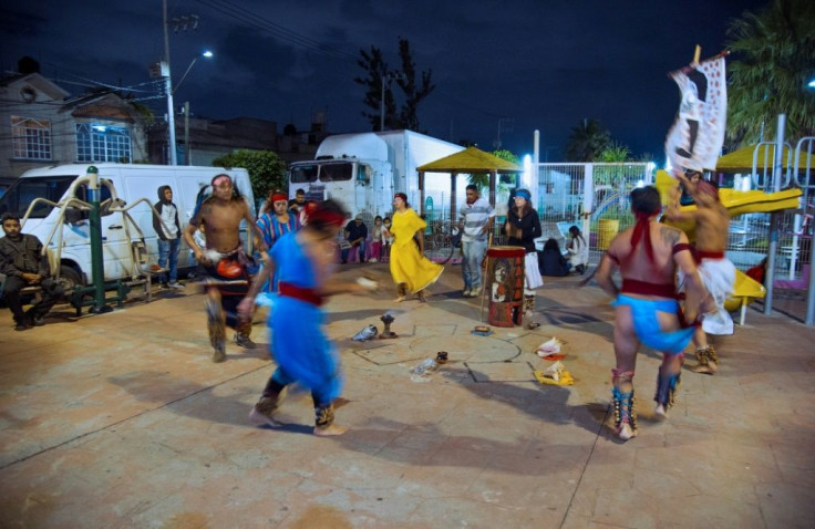 Members of Mexican rock band Los Cogelones perform an Aztec ritual dance with friends in the streets of Ciudad Nezahualcoyotl