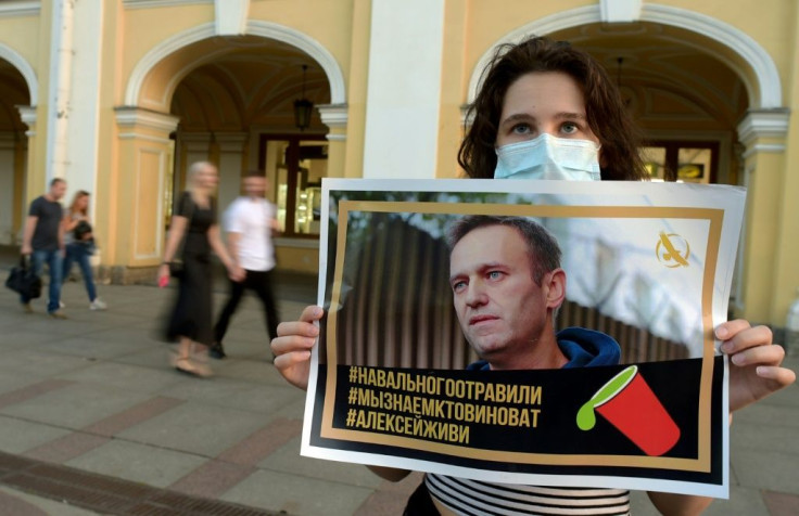 A woman holding a placard with an image of Alexei Navalny expresses support for the opposition leader after he was rushed to intensive care in Siberia suffering from what his spokeswoman said was a suspected poisoning