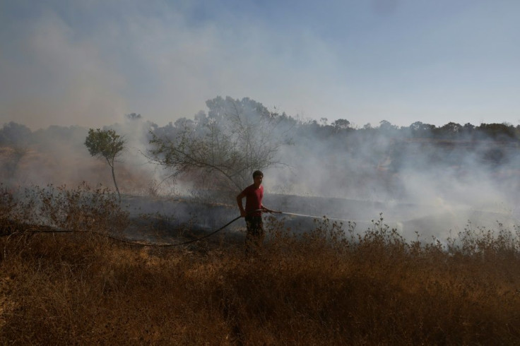 An Israeli firefighter extinguishes a fire close to the Gaza Strip caused by an incendiary balloon