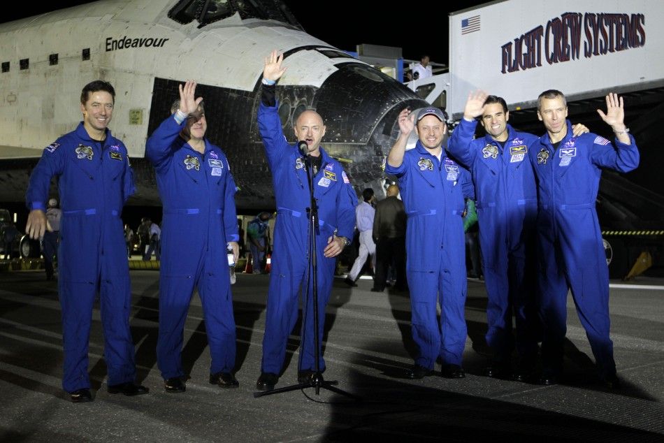 The crew of space shuttle Endeavour wave after landing in Cape Canaveral