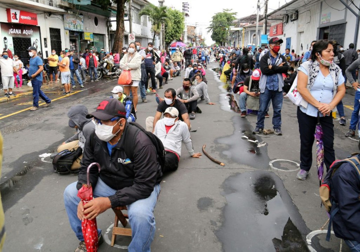 Dozens of Peruvians queue in Iquitos to receive government issued food tokens to help ease the economic strife induced by the coronavirus