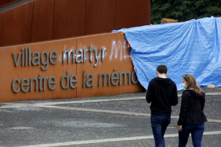 The defaced entrance sign for the memorial at Oradour-sur-Glane, where Nazis slaughtered 642 people on June 10, 1944