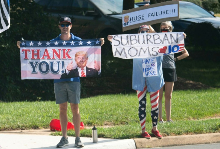 Rival supporters of Donald Trump and Joe Biden hold signs as Trump's motorcade arrives at Trump National Golf Club in Sterling, Virginia, August 23, 2020