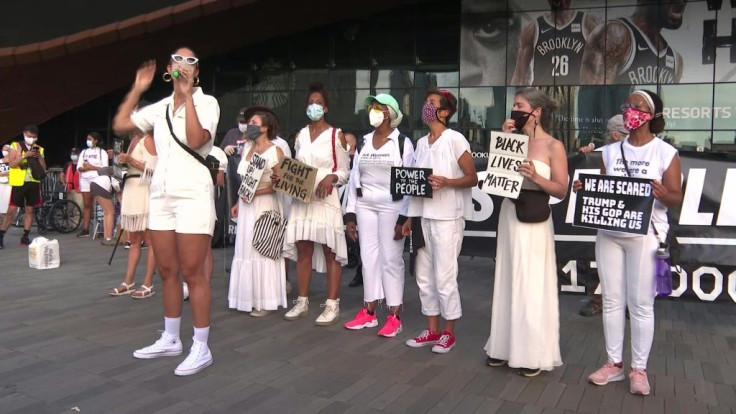 About a hundred protesters dressed in white gather in front of the Barclays Center in Brooklyn, New York, to denounce Donald Trump's response to the COVID-19 pandemic