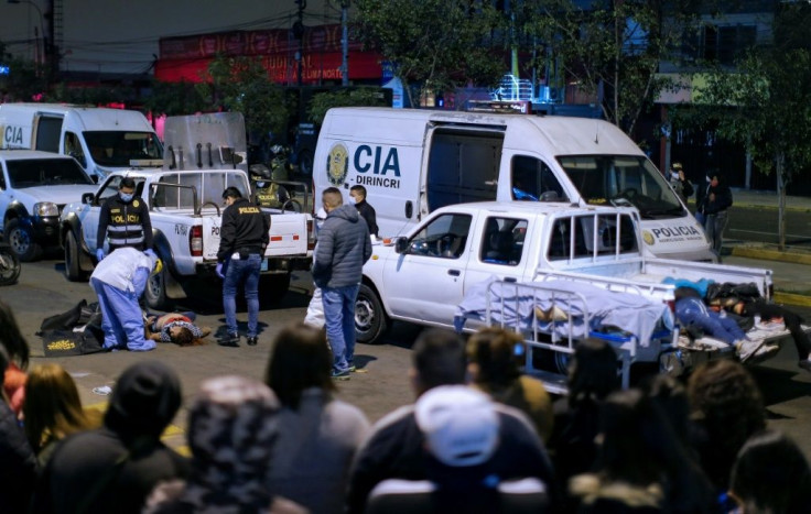 The bodies of 13 people who suffocated in a crush during a police raid in Lima, Peru on August 22 are loaded onto pick-up trucks outside the nightclub where a party was held in violation of a ban on such gatherings imposed to fight COVID-19