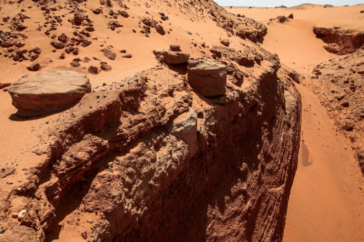 Sudanese treasure hunters use mechanical diggers to cut deep trenches at ancient sites looking for gold