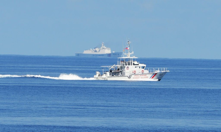 A Philippine coastguard ship BRP Langgam sails past a Chinese coastguard ship (background) near the Scarborough shoal in 2019