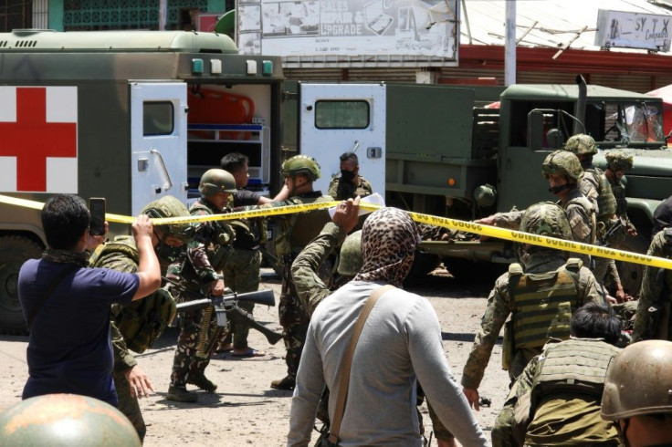 Military personnel stretcher away some of the victims of the Jolo blasts