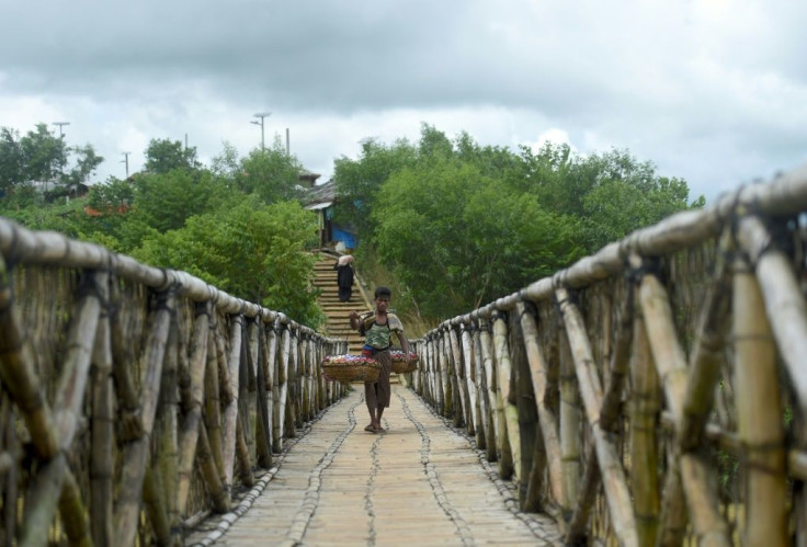 A Rohingya worker walks across a bamboo bridge in Kutupalong refugee camp in Ukhia, Bangladesh