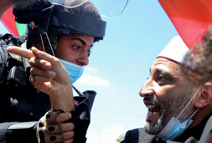 A Palestinian demonstrator argues with Israeli security forces during a protest rally in the occupied West Bank, in the village of Haris, southwest of Nablus, on August 21
