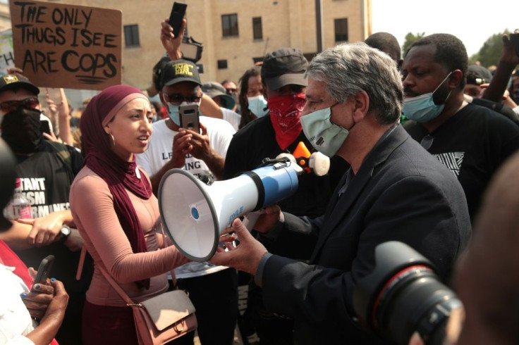 Kenosha Mayor John Antaramian uses a bull horn to talk to people gathered in front of the police station