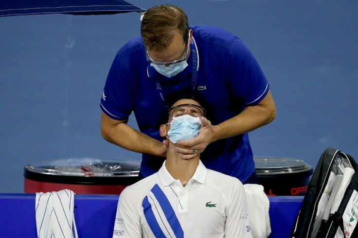 Serbia's world number one Novak Djokovic receives treatment on his sore neck on the way to a second-round win over Ricardas Berankis in the Western & Southern Open