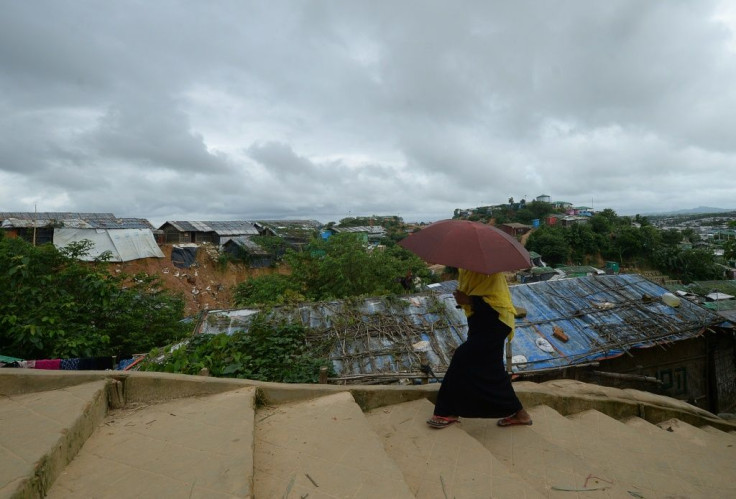 A Rohingya woman climbs a hill as she goes back to her makeshift home in Jamtoli refugee camp, near Ukhia in Bangladesh