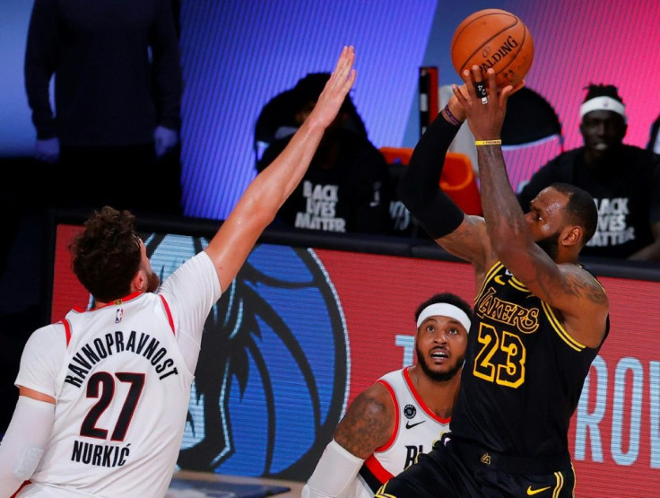 Los Angeles Lakers forward LeBron James shoots against Jusuf Nurkic, 27, of the Portland Trail Blazers during the third quarter in game four of the Western Conference playoff series in Orlando