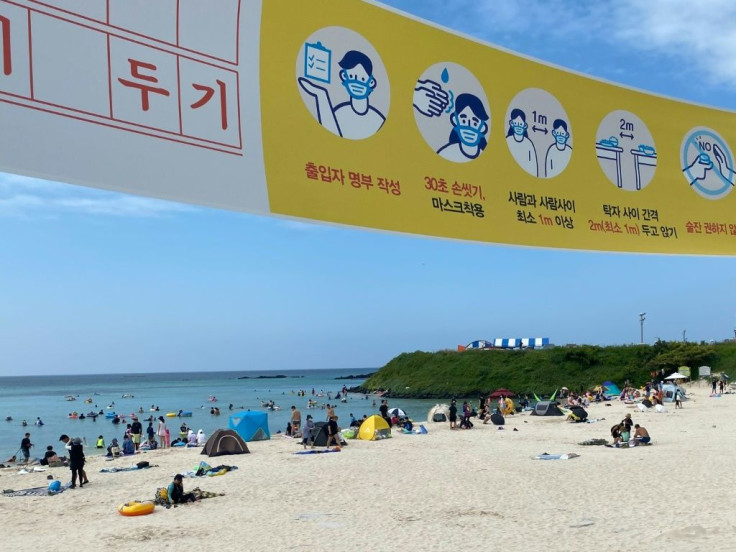 A banner advises South Korean beachgoers to follow health guidelines