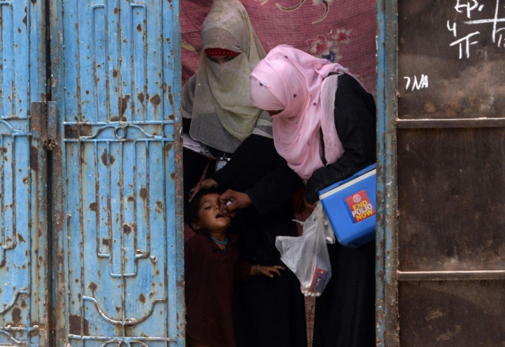 A Pakistani health worker administers polio vaccine to an Afghan refugee in Lahore
