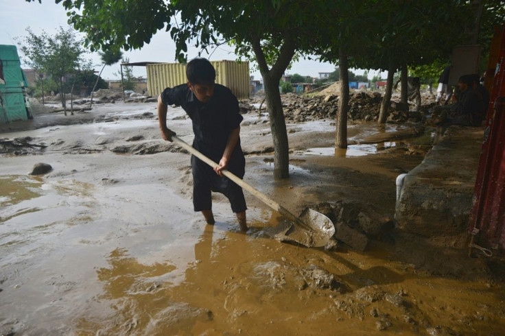 A resident clears mud in Charikar after flash floods killed nearly 50 people