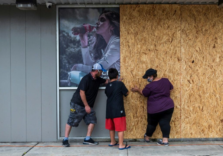People board up a shop in Lake Charles, Louisiana before the arrival of Hurricane Laura
