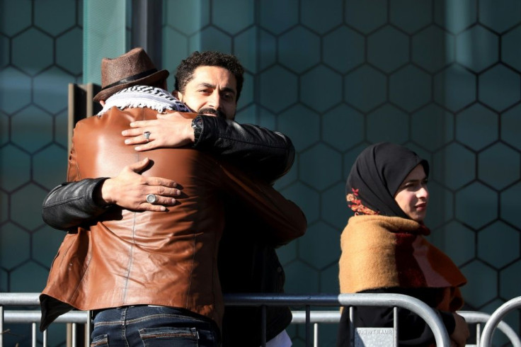 Survivors and family members of the 2019 twin mosque shootings greet each other outside the High Court building in Christchurch