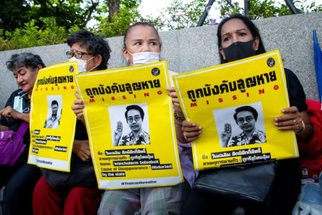 Protesters hold posters showing missing Thai activist Wanchalearm Satsaksit during a rally in Bangkok