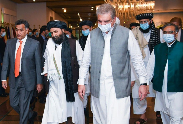 Pakistan's Foreign Minister Shah Mehmood Qureshi (third right) walks with Taliban co-founder Mullah Abdul Ghani Baradar (second left) ahead of talks in Islamabad intended to push for peace talks