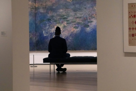 A man looks at Claude Monet's "Water Lilies" as the Museum of Modern Art (MoMA) reopen its doors to the public on August 27, 2020 in New York after being shuttered since March 12, 2020 due to Covid-19
