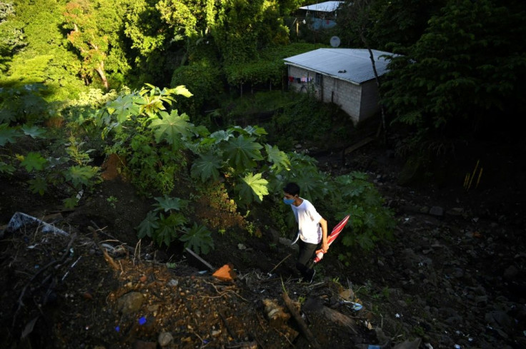 Erick Palacios, 22, climbs up a hill searching for internet signal to attend a virtual university class, in Huizucar, El Salvador